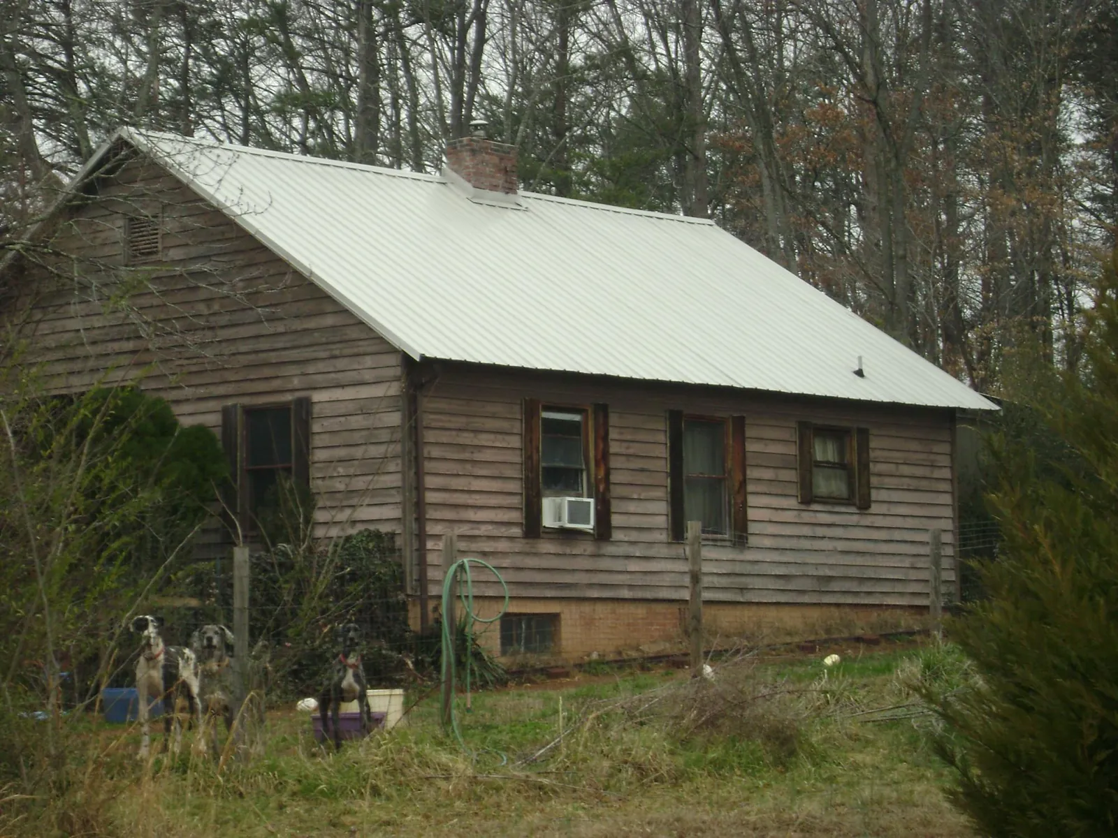 White metal roof on an old wood sided farmhouse, from a Metal Roof Installation job in Haskell